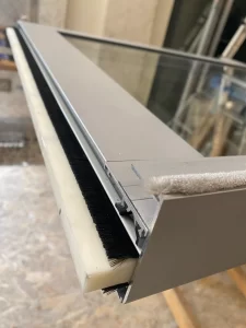 Dettaglio della bussola automatica in vetro a Palazzo Trentini: profilo in pvc che garantisce per tutta la larghezza la tenuta al passaggio dell’aria
