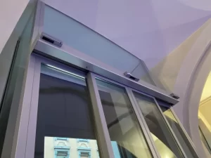 Dettaglio della bussola automatica in vetro a Palazzo Trentini: automazione ridondante e sopraluce incassato nel soffitto a volta
